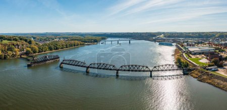 Photo for Aerial view of historic Dubuque railroad bridge between Iowa and Illinois across the Mississippi river with cruise boat in distance - Royalty Free Image