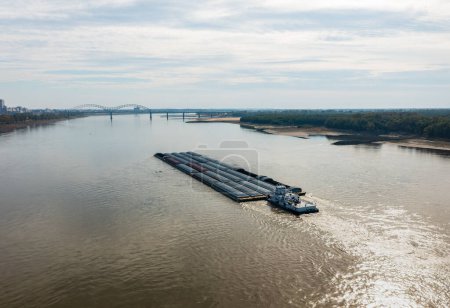 Extreme low water conditions on Mississippi river under Hernando de Soto bridge in Memphis TN as barge sails downstream