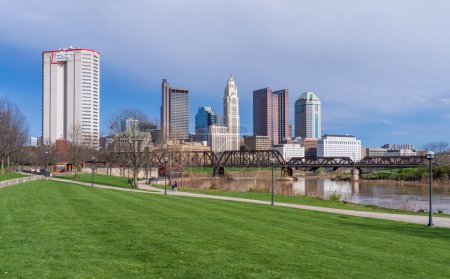 Photo for Columbus, OH - 7 April 2024: Waterfront view of the downtown financial district from the River Scioto through a railroad truss bridge - Royalty Free Image