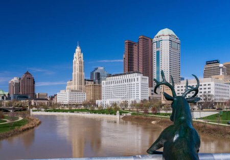 Photo for Columbus, OH - 7 April 2024: Deer statue by Terry Allen overlooking the skyline by the river Scioto - Royalty Free Image