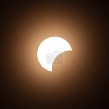 Foto de Etapa inicial del eclipse solar en abril de 2024 con la luna empezando a cubrir el sol - Imagen libre de derechos