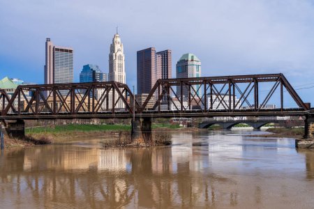 Columbus Ohio Blick auf das Finanzviertel der Innenstadt vom Fluss Scioto aus durch eine Eisenbahnfachwerkbrücke