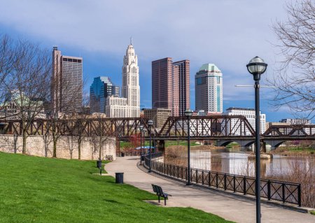 Photo for Columbus Ohio waterfront view of the downtown financial district from the River Scioto through a railroad truss bridge - Royalty Free Image