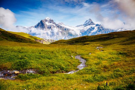 Foto de Gran vista de las colinas brumosas alpinas y el arroyo glaciar. Pintoresca y hermosa escena. Ubicación lugar Alpes suizos, valle de Grindelwald, Bernese Oberland, Europa. Descubre el mundo de la belleza. - Imagen libre de derechos