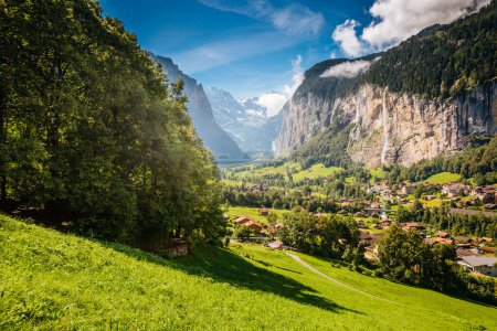 Photo for Vivid view of alpine village glowing by sunlight. Picturesque and gorgeous scene. Popular tourist attraction. Location place Swiss alps, Lauterbrunnen valley, Staubbach waterfall, Europe. Beauty world - Royalty Free Image
