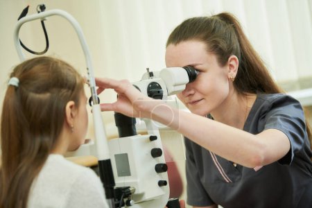 Foto de Oftalmología. doctora optometrista comprueba la vista de la joven. BeH3althy - Imagen libre de derechos