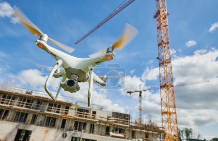 Téléchargez les photos : Drone volant sur le chantier de construction. Surveillance vidéo ou inspection de la sécurité industrielle dans la zone du bâtiment - en image libre de droit