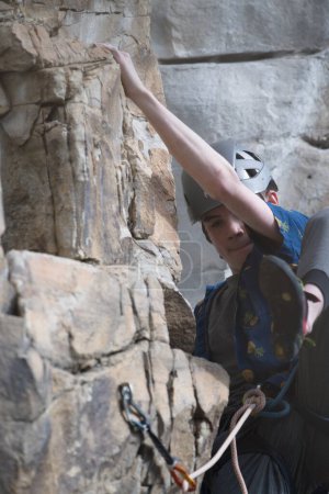 Photo for Male climber finding proper foot position on rock climb. - Royalty Free Image