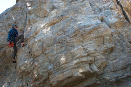 Téléchargez les photos : Homme grimpeur sur paroi rocheuse saisir fissure dans la roche - en image libre de droit