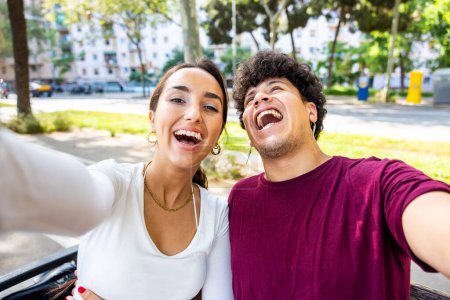 Foto de Pareja feliz tomando una selfie riendo y divirtiéndose - Hombre y mujer disfrutando de un día soleado y caluroso en Barcelona - Conceptos de estilo de vida y felicidad - Imagen libre de derechos