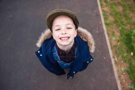 Foto de Retrato alegre de niño desde arriba - Niño mirando a la cámara y sonriendo con una mueca divertida - Infancia y despreocupado - Imagen libre de derechos