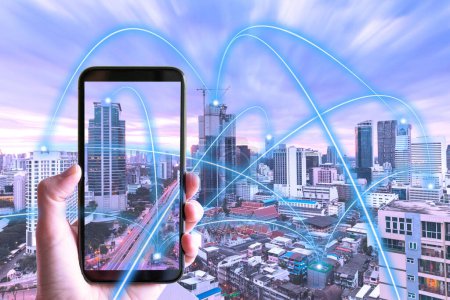 Téléchargez les photos : Main tenant smartphone contre paysage urbain avec des graphiques de connectivité ar - Concept de connexion de ville intelligente réalité augmentée - en image libre de droit