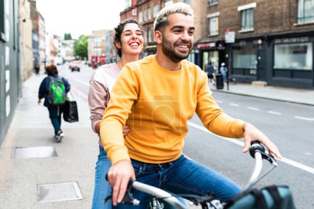 Téléchargez les photos : Heureux couple caucasien en vélo à Londres - jeune homme et jeune femme souriant et riant utilisant un service de vélo partagé dans la ville - mode de vie, Voyage et bonheur - en image libre de droit