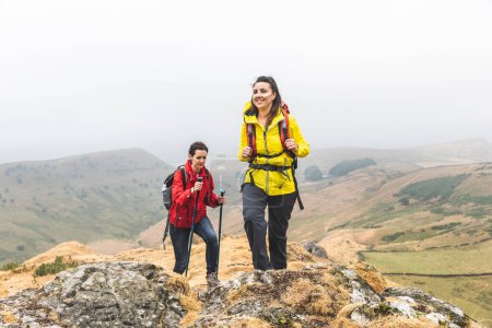 Téléchargez les photos : Deux jeunes femmes passent la journée en plein air en randonnée dans la nature à travers le Peak District au Royaume-Uni - Nature et concepts de voyage - en image libre de droit
