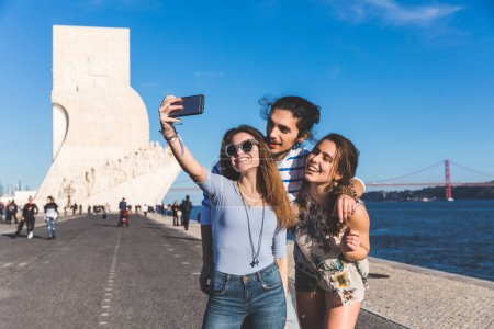 Téléchargez les photos : Amis voyageant et prenant un selfie ensemble à Lisbonne passer du temps de qualité par une journée ensoleillée à Belem - Concepts d'amitié et de style de vie - en image libre de droit