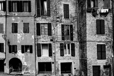 Foto de La arquitectura de la ciudad medieval italiana Siena, antigua fachada, ventanas con persianas y el espíritu de la antigüedad en blanco y negro - Imagen libre de derechos