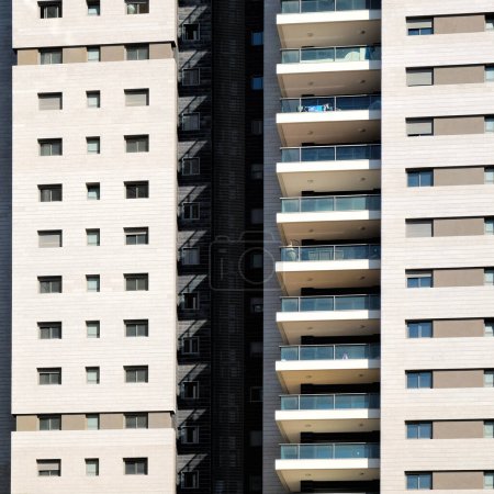 Foto de Fachada de vivienda con ventanas armónicas en una fila. Ventanas y balcones de una casa de apartamentos multihabitación de edificio de masas en Israel - Imagen libre de derechos