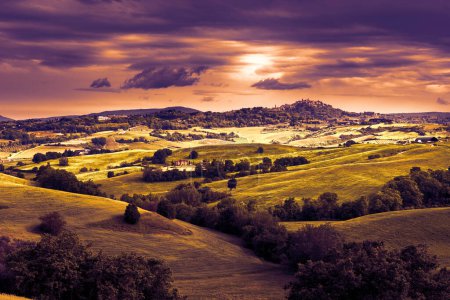 Foto de Ciudad medieval italiana Montepulciano en la colina, horizonte y paisaje rural con viñedos y olivos al atardecer - Imagen libre de derechos