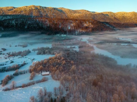 Foto de Beautiful view of nature scene with frozen river and trees. aerial view of rural landscape in wintertime - Imagen libre de derechos