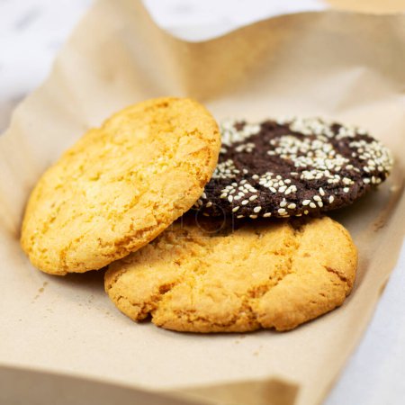 Téléchargez les photos : Appetizing cookies with seeds on paper close-up - en image libre de droit