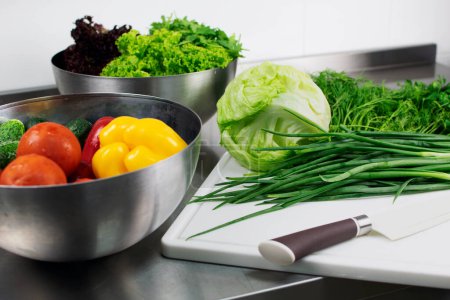 Téléchargez les photos : Fresh vegetables in a stainless steel bowl ready for cutting with a knife - en image libre de droit