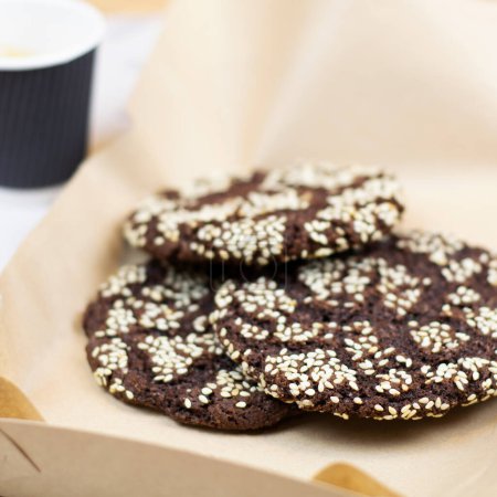 Foto de Galletas de chocolate con semillas en papel de primer plano. Postre con café. - Imagen libre de derechos