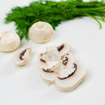 Photo for Sliced champignon mushroom. Bunch of dill in the background. - Royalty Free Image