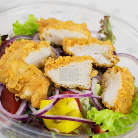Téléchargez les photos : Salade avec morceaux de poulet pané close-up - en image libre de droit