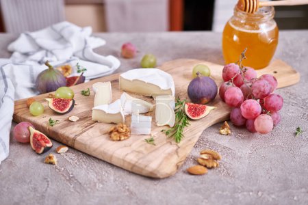 In Scheiben geschnittener Camembert oder Brie-Käse auf Holzschneidebrett in der heimischen Küche.