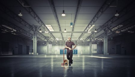 Photo for Stanging man with handtruck in warehouse - Royalty Free Image