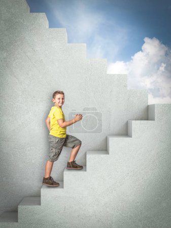 Téléchargez les photos : Enfant souriant grimpant des escaliers en béton. ciel bleu en arrière-plan - en image libre de droit