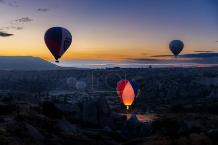 Foto de GOREME/TURKEY - June 29, 2022: Hot air balloons fly at dawn over the hills of Goreme. - Imagen libre de derechos