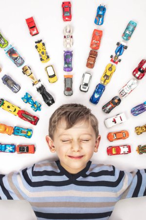 Téléchargez les photos : Portrait of Caucasian child with toy cars on white - en image libre de droit