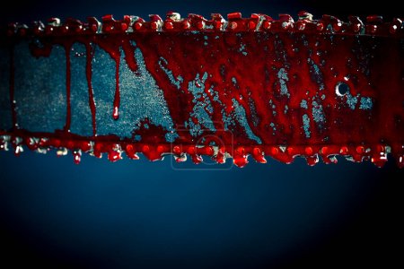 Téléchargez les photos : Chainsaw stained with blood dark background - en image libre de droit
