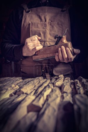 Photo for Carpenter with leather apron holding a planer - Royalty Free Image