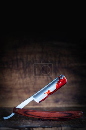 Téléchargez les photos : Rasoir traditionnel recouvert de sang sur fond de bois - en image libre de droit