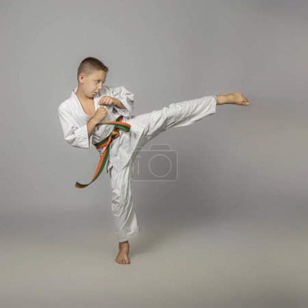 Photo for Boy performs a side kick, martial arts - Royalty Free Image