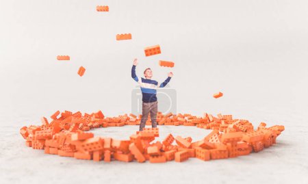 Foto de Niño feliz mirada ladrillos de juguete en el aire, rodeado por un círculo de bloques - Imagen libre de derechos