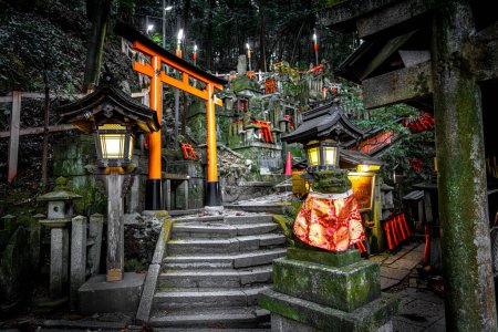 Foto de Faroles iluminados iluminan los senderos serpenteantes y puertas torii en el santuario inari fushimi, kyoto - Imagen libre de derechos