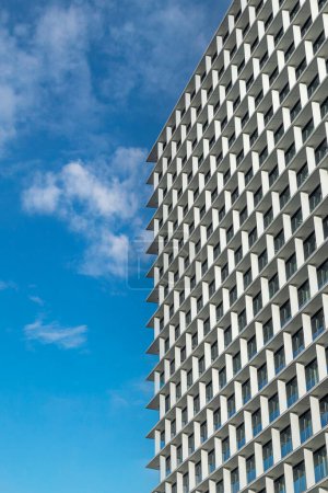 Fachada geométrica de un edificio contemporáneo con un fondo de cielo azul claro