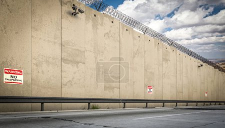 Grenze Betonmauer gekrönt Stacheldraht kein Überschreiten Warnschilder