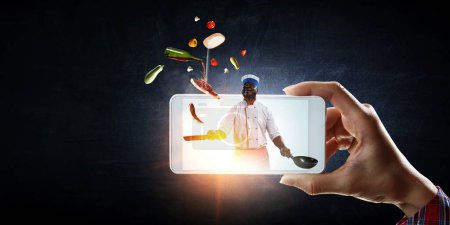 Téléchargez les photos : Image du chef sur l'écran du téléphone portable. Techniques mixtes - en image libre de droit