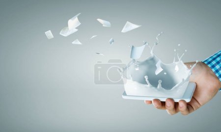 Photo for Hand holding smart mobile phone and paper flying away. Mixed media - Royalty Free Image