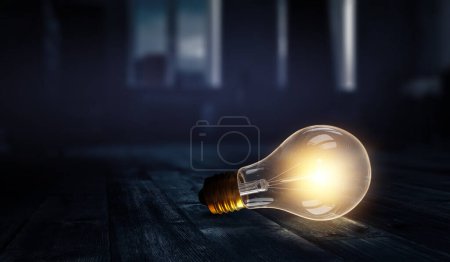 Foto de Enorme bombilla eléctrica que brilla en la oscuridad. Medios mixtos - Imagen libre de derechos