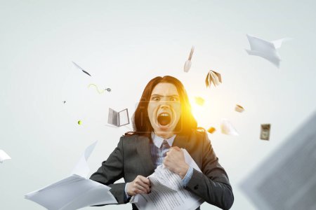 Téléchargez les photos : Jeune femme stressée folle au travail, déchirant des documents avec une expression faciale frustrée. Techniques mixtes - en image libre de droit