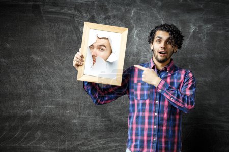 Téléchargez les photos : Visage masculin à travers le trou dans le papier. Techniques mixtes - en image libre de droit