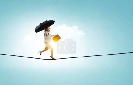Photo for Businesswoman running with umbrella. Mixed media - Royalty Free Image