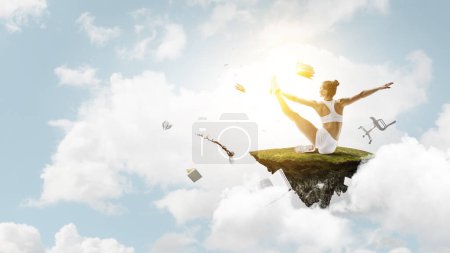 Photo for Young beautiful girl wearing fashion sports wear doing exercise with clouds on background. Mixed media - Royalty Free Image