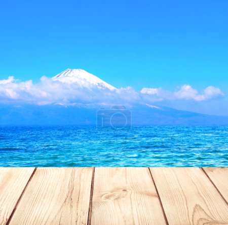 Photo for Beautiful sacred Mount Fuji, lake and old wooden plank, Japan. Empty wooden table top and scenic with pond and Fujiyama volcano. Rustic wood table. Mock up template. Copy space for text - Royalty Free Image