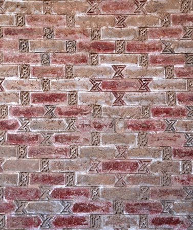 Photo for Full vertical texture of old brick wall with decorative clay elements - Royalty Free Image